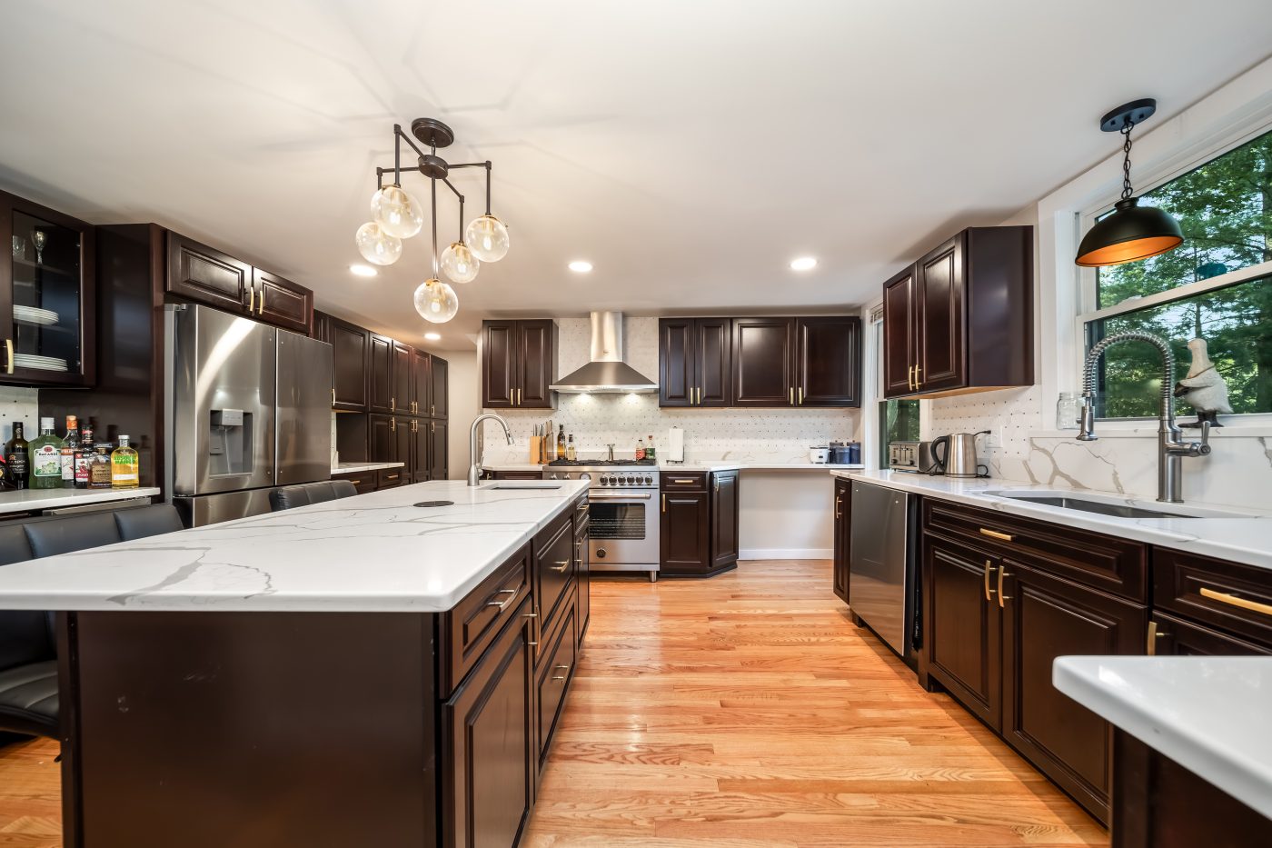 Kitchen with a centre island, quartz counters and dark cabinetry