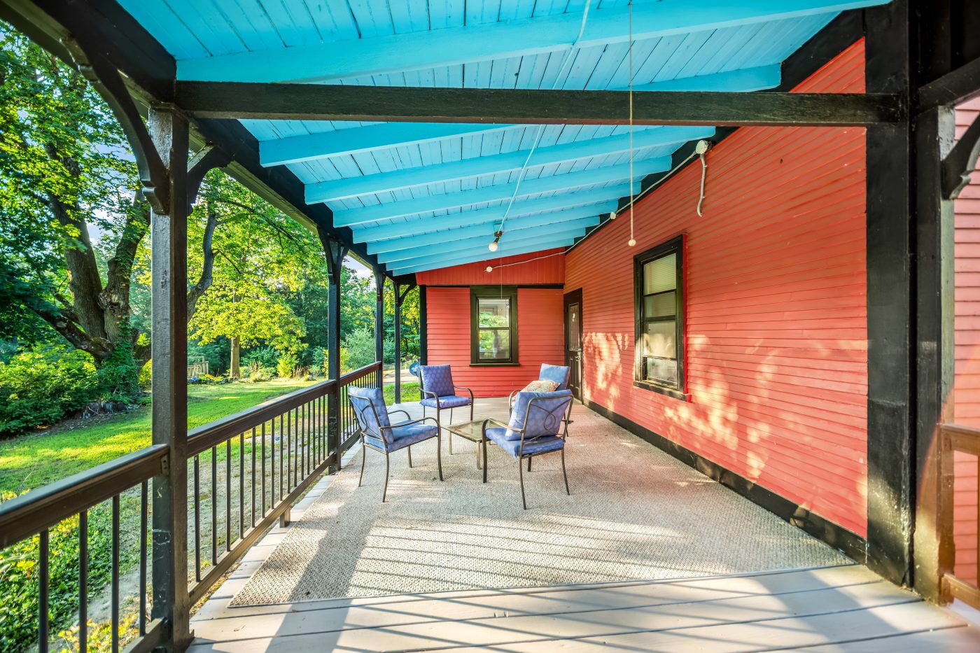 The covered porch along the side of the house, painted deck and turquoise ceiling